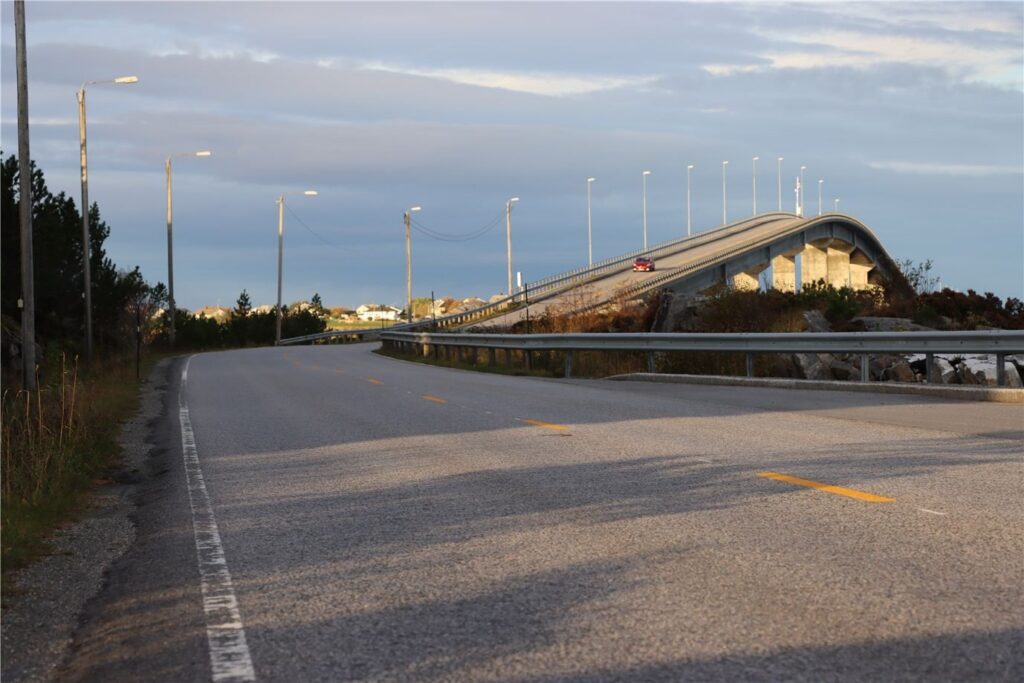 Her susar bilane over Giskebrua i 80 kilometer i timen. Gang- og sykkelvegen er enno ikkje fullført ved denne fylkesvegen. (Arkivfoto)